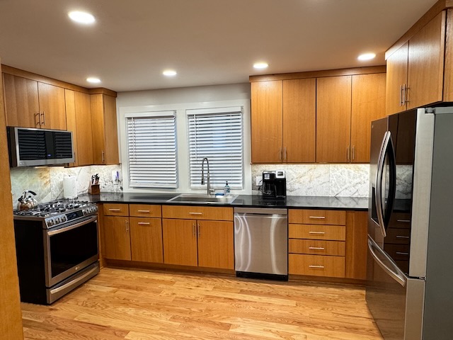 Beautifully renovated kitchen interior with natural colored wood cabinets, new stainless steel appliances, and ample lighting.